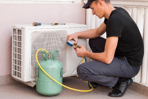 A professional technician performing a freon air conditioner refill so the refrigerant levels are satisfactory enough to keep the home in Newark, OH, cool and comfortable.